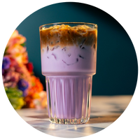 Glass of layered iced coffee and purple ube milk with a blurred floral background