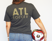 woman wearing game day shirt and holding soccer ball