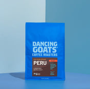 Blue bag of Dancing Goats Coffee Roasters Peru coffee on a blue background