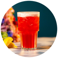 Glass of red hibiscus tea with lemons on a blurred background