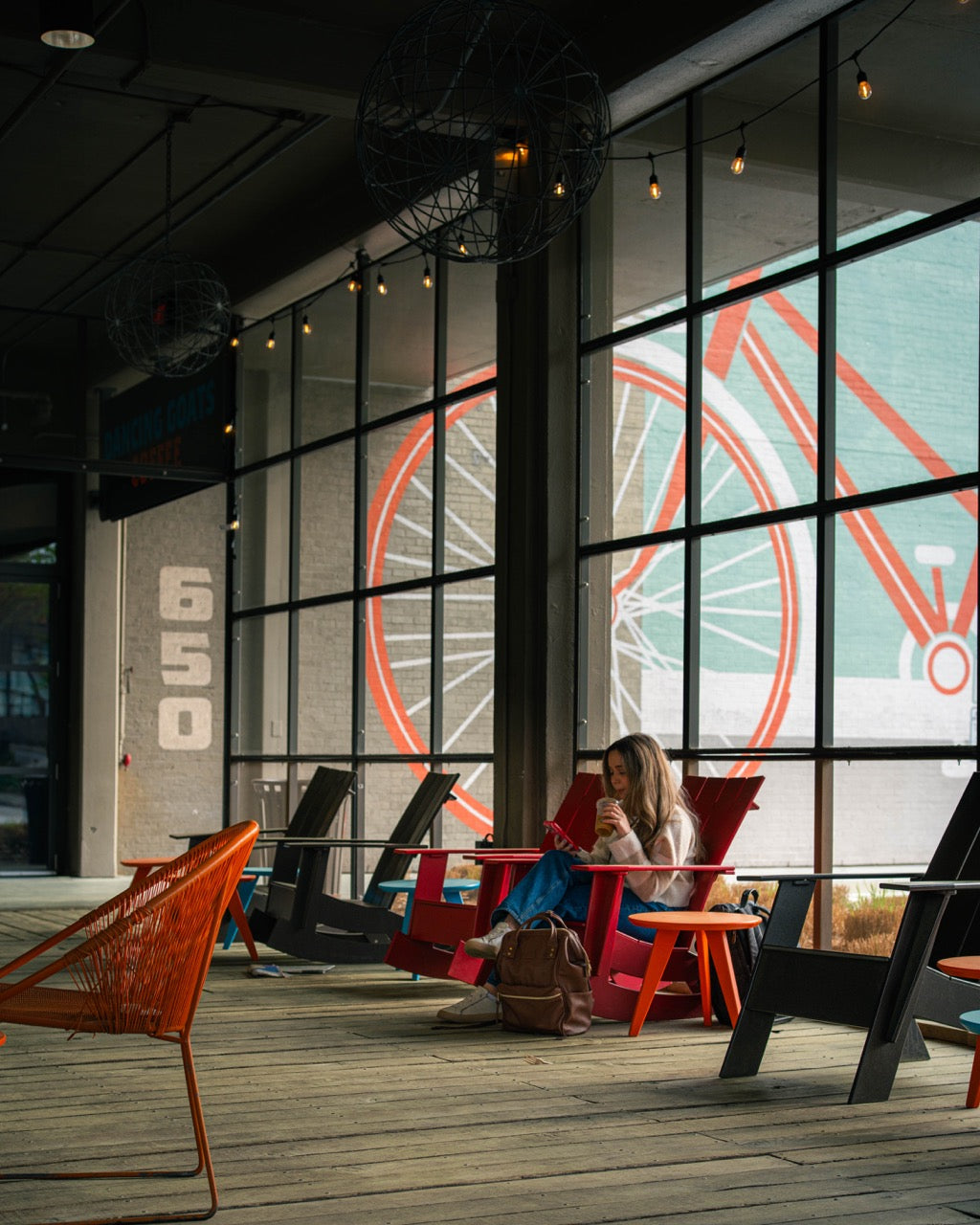 Person sitting in a modern indoor setting with large windows showing a Ferris wheel.