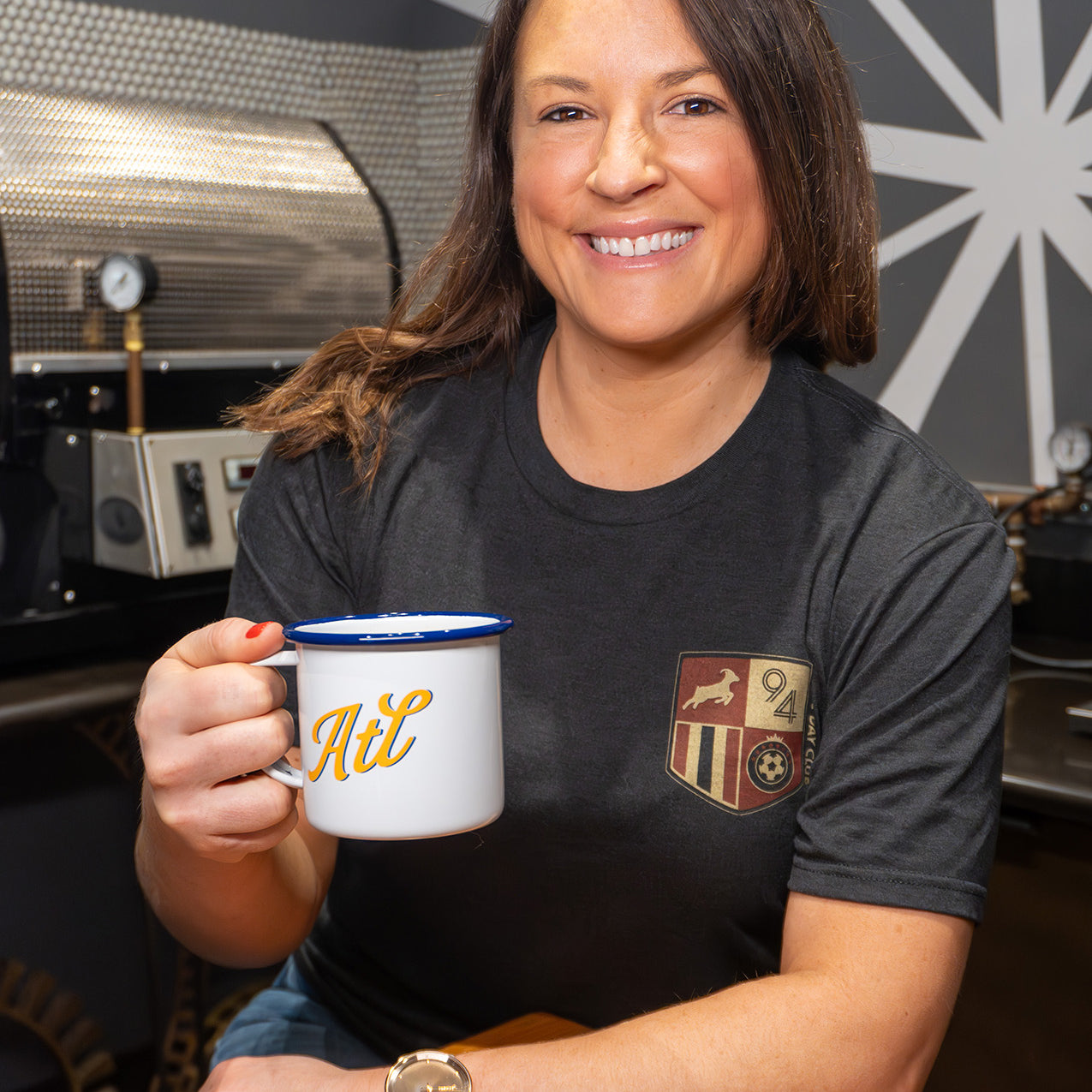 woman smiling while holding mug of coffee and wearing game day shirt