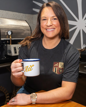 woman smiling while holding mug of coffee and wearing game day shirt