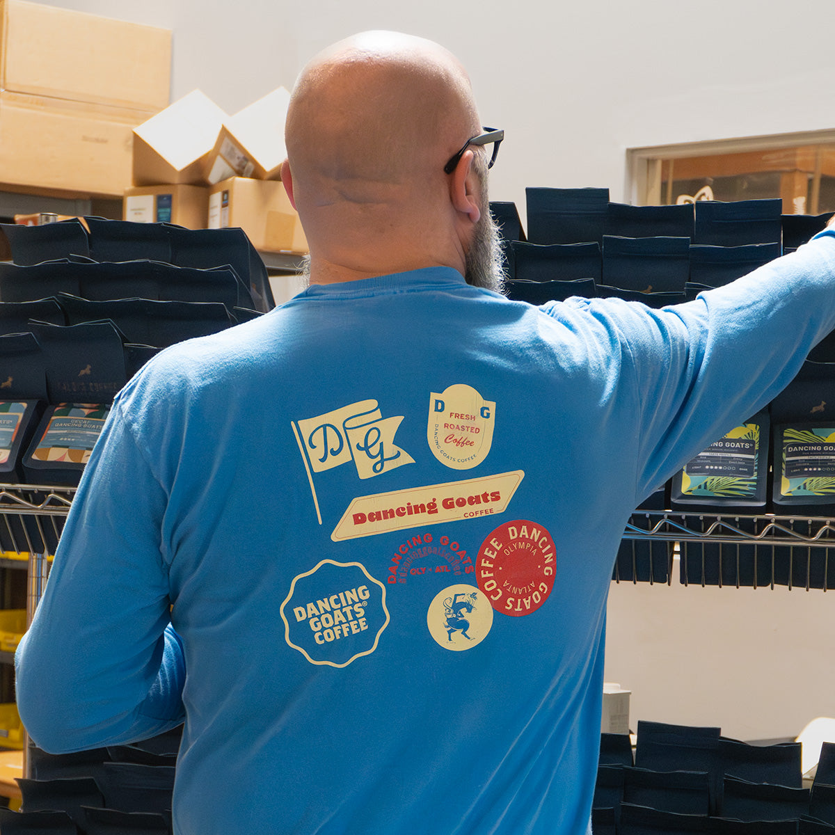 back of man wearing blue long sleeve dancing goats shirt