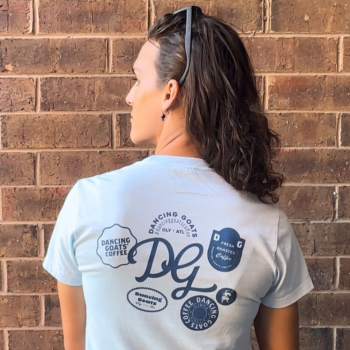 back of person wearing Dancing Goats light blue boxy fit cropped tee