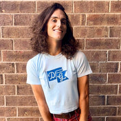 smiling person wearing Dancing Goats light blue boxy fit cropped tee