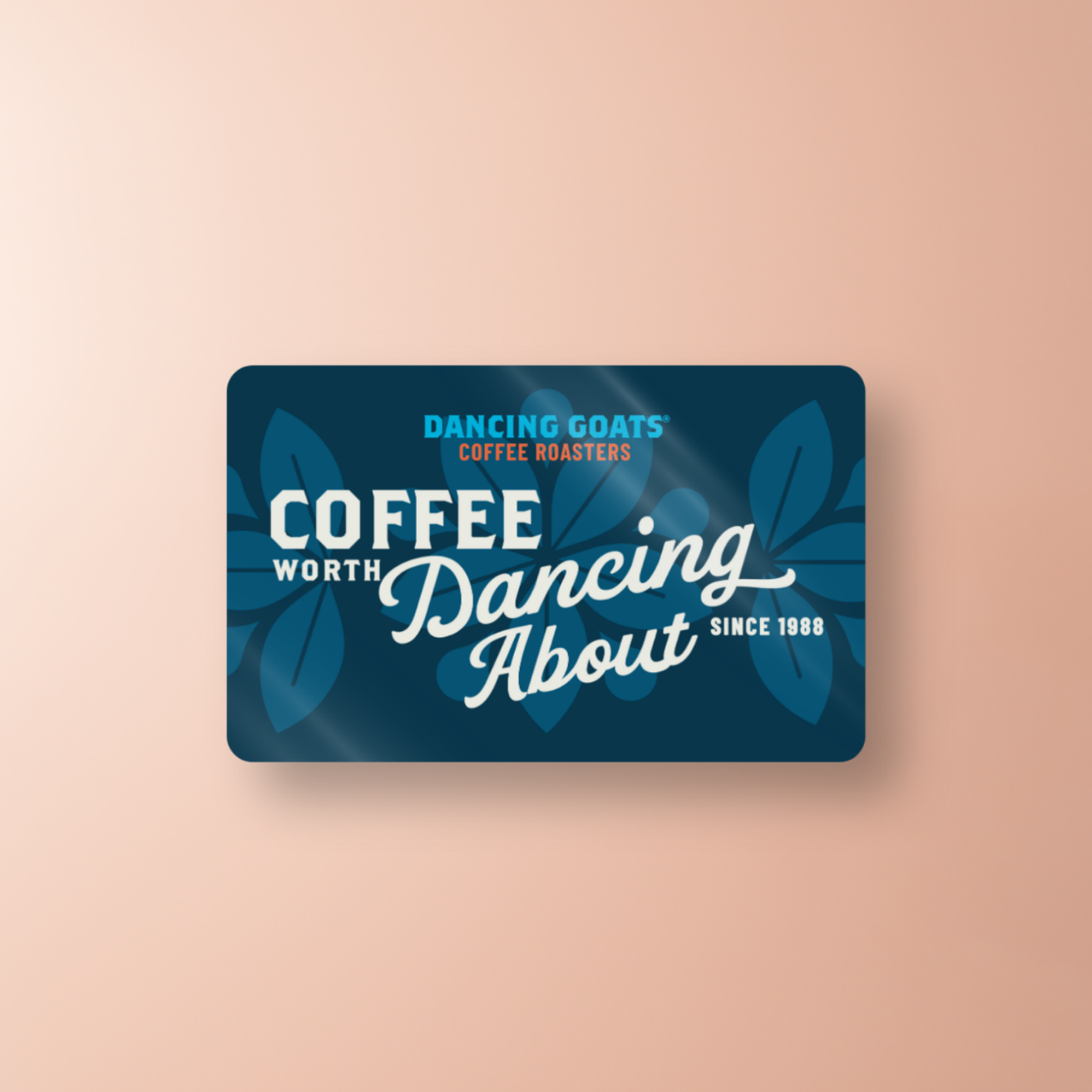 navy blue gift card with dancing goats logo and words: coffee worth dancing about since 1988. on gradient peach background