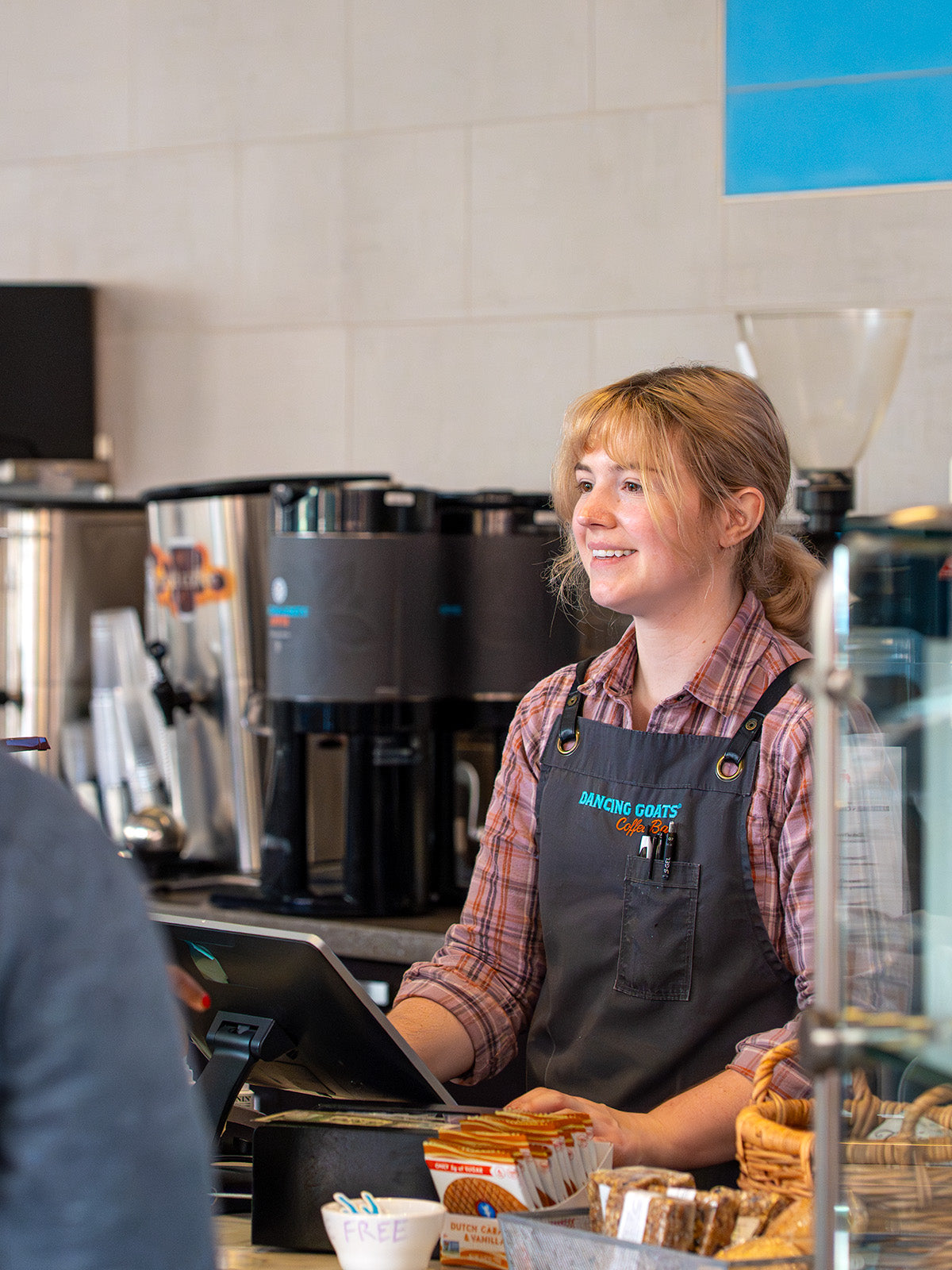 Person wearing a apron in a coffee shop setting