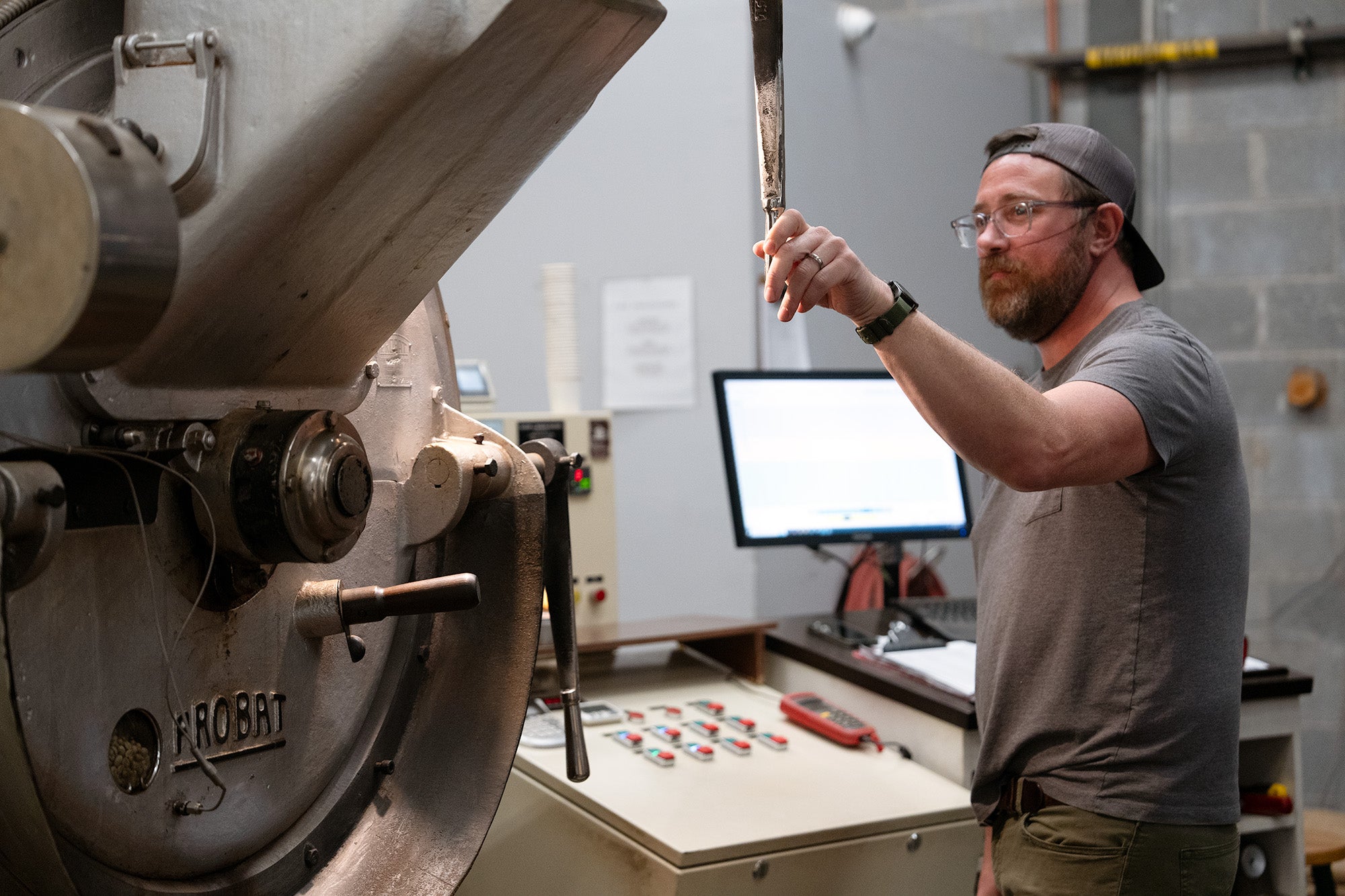Man operating a roasting machine in a roastery